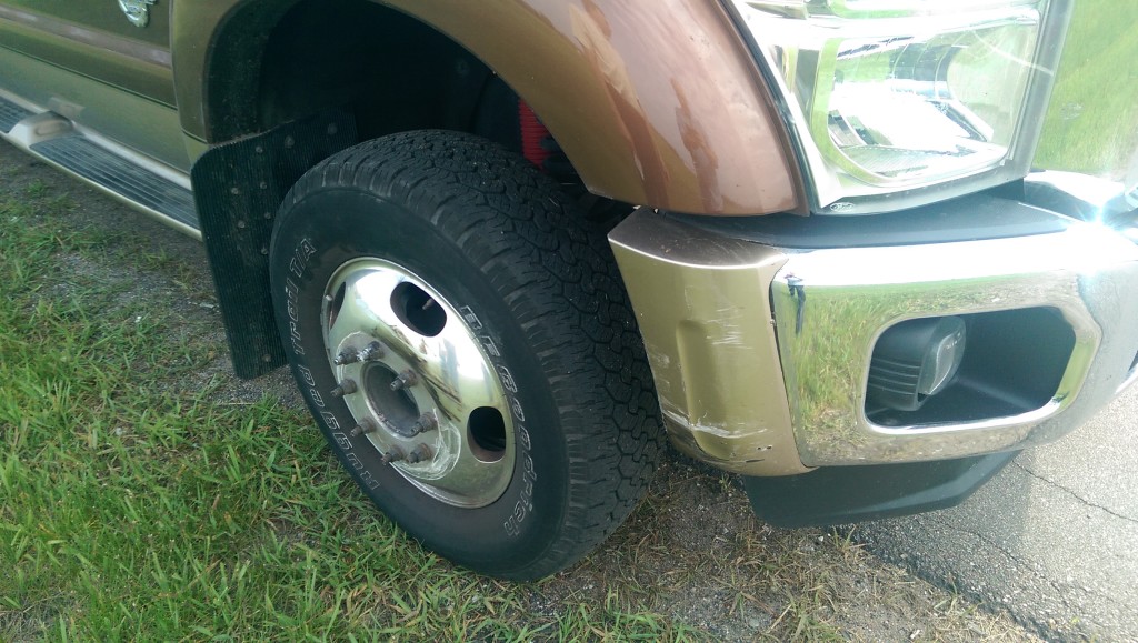 Damage to end of bumper, wheel cover and wheel